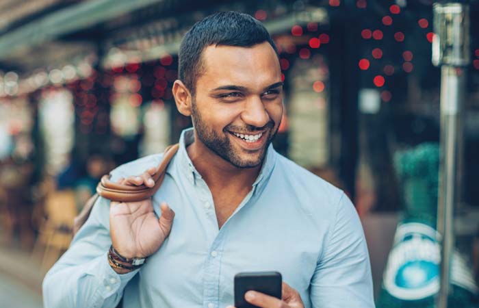 Man smiling while holding a cellphone