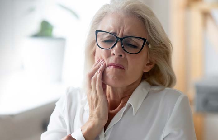 older woman holding face in pain